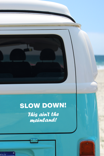 rear of a volkswagen van with bumper sticker "slow down! This ain't the mainland."